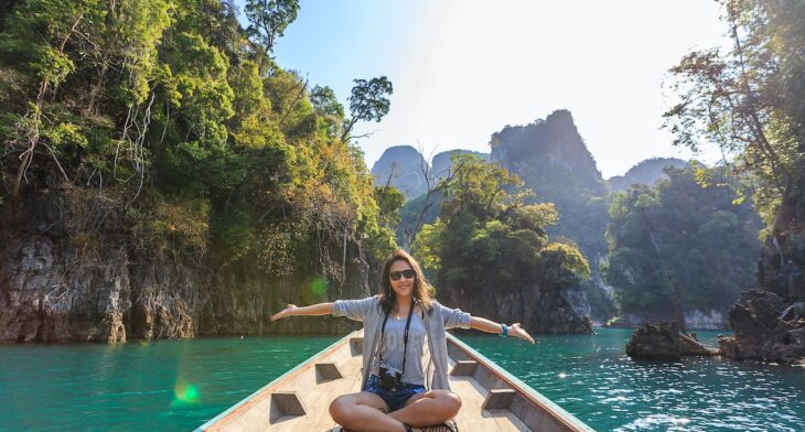 photo of woman sitting on top of boat while travelling
